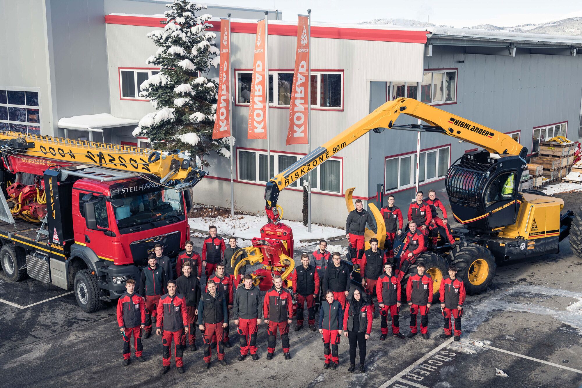 Construction workers standing in front of heavy machinery and a building