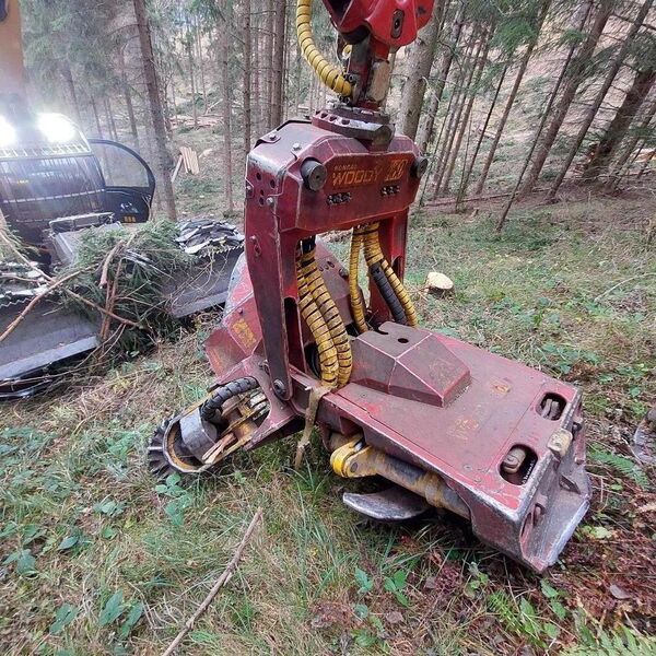 Forestry machine actively cutting trees in a wooded area