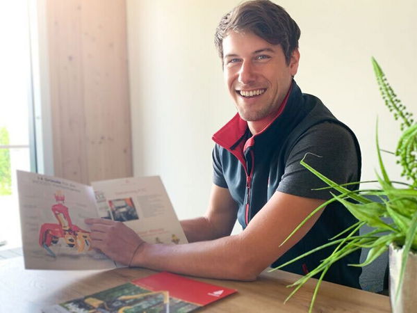 Smiling man holding a brochure and offering consultation