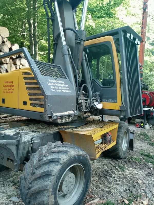 Yellow forest logging equipment in operation within a bustling green forest