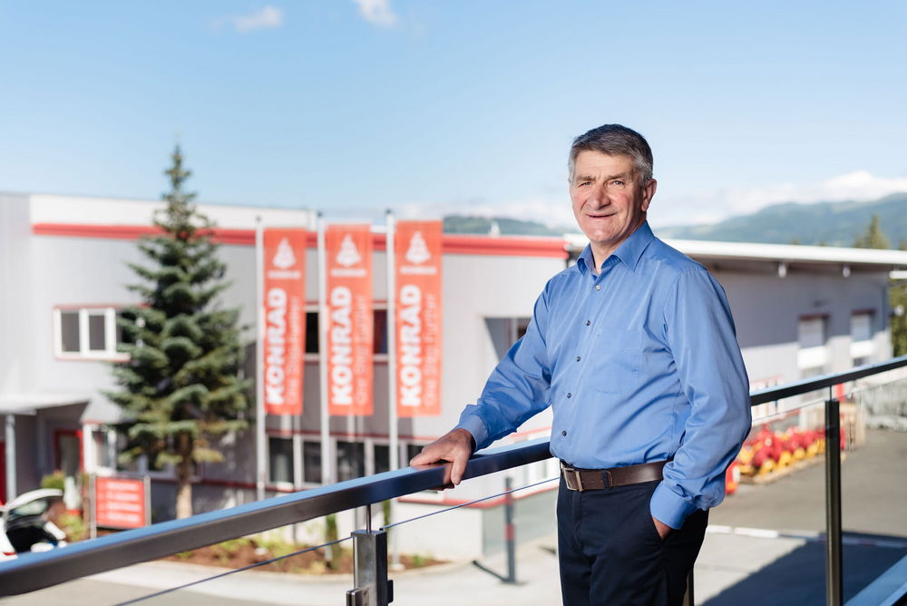 Josef Konrad standing in front of the Konrad company building with banners