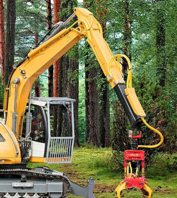 Excavator with attachment in wooded area