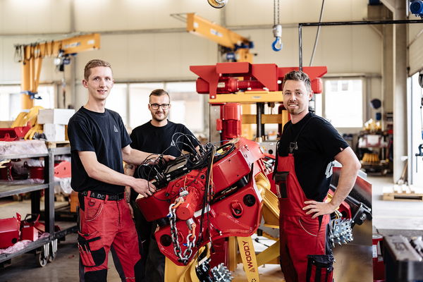 Three engineers collaboratively working on forestry machinery at Konrad Forsttechnik